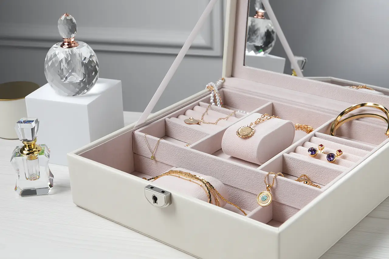 een wit houten sieradenkistje gevuld met sieraden als cadeau voor een houten huwelijk